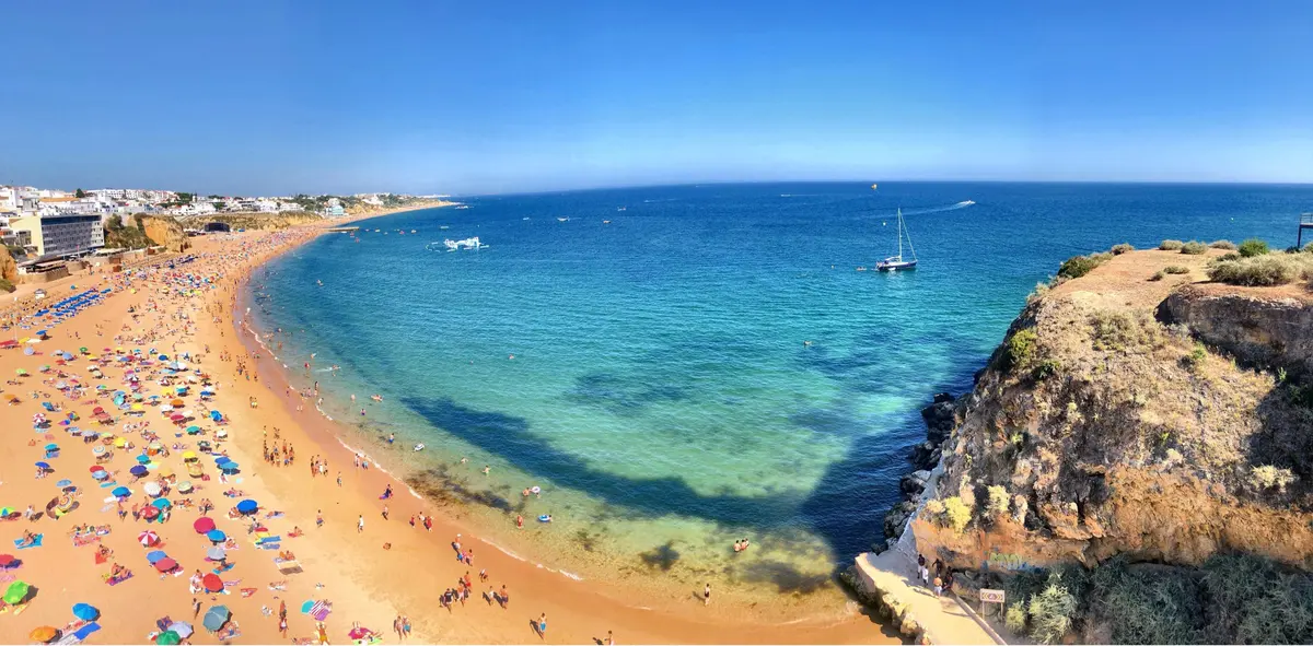 Summer beachgoers and turquoise water along the Albufeira seafront