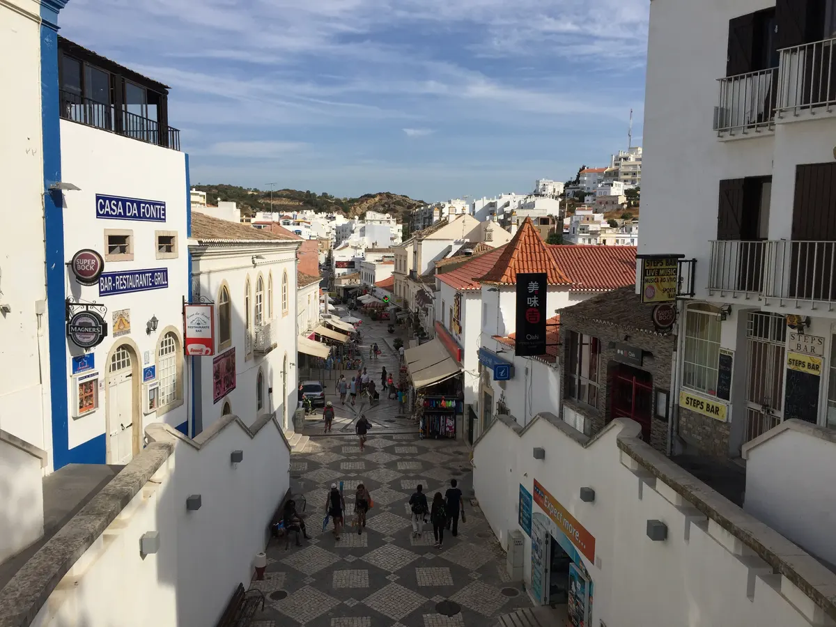 Whitewashed buildings and patterned paving on Rua 5 de Outubro in Albufeira old town