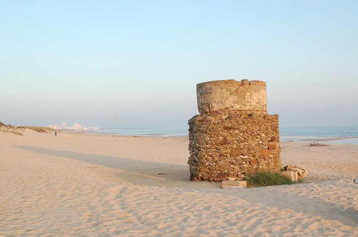 An old tower structure on the sandy beach at Praia Verde