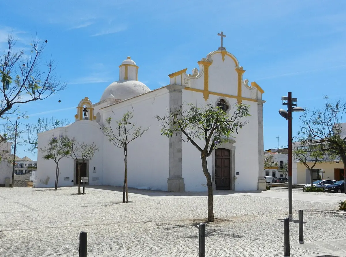 White exterior of São Sebastião chapel beneath a blue sky in Tavira