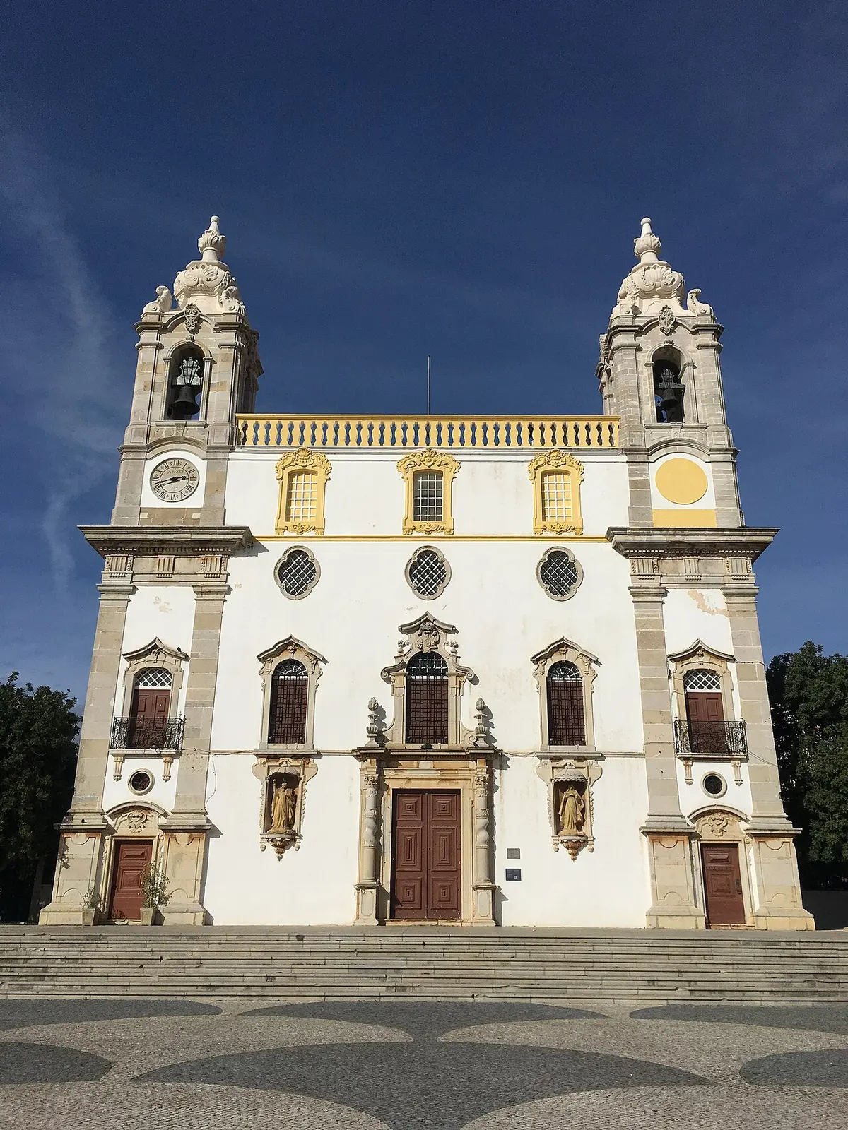 White and ochre façade with twin bell towers at Igreja do Carmo in Faro