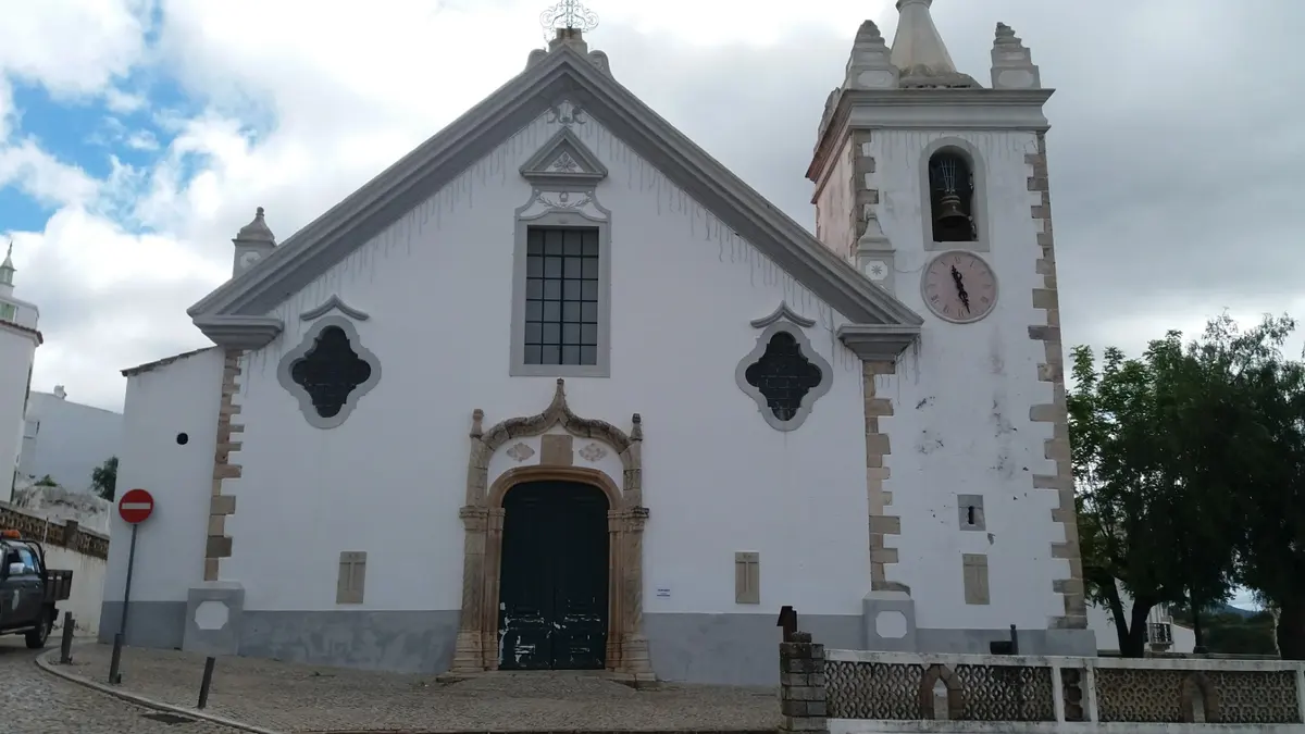 The front of Alte parish church with its decorated doorway and bell tower