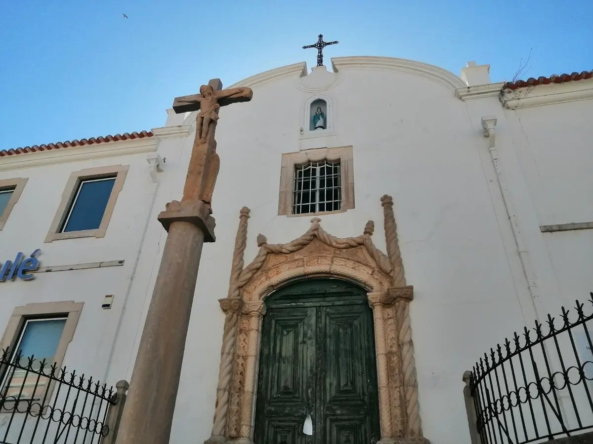 A stone cross beside the ornate doorway of Loulé’s Misericórdia church