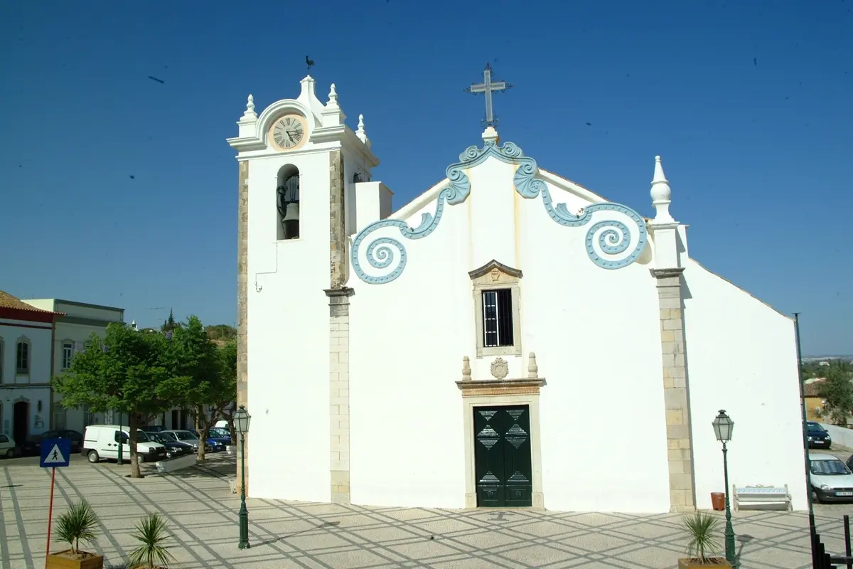 The white facade and bell tower of São Sebastião church in Boliqueime