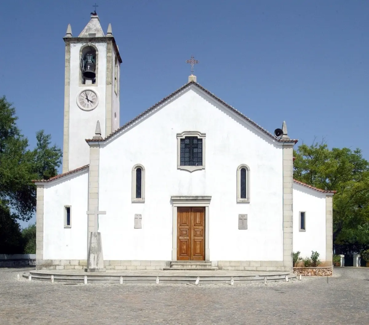 The white facade and clock tower of Salir parish church