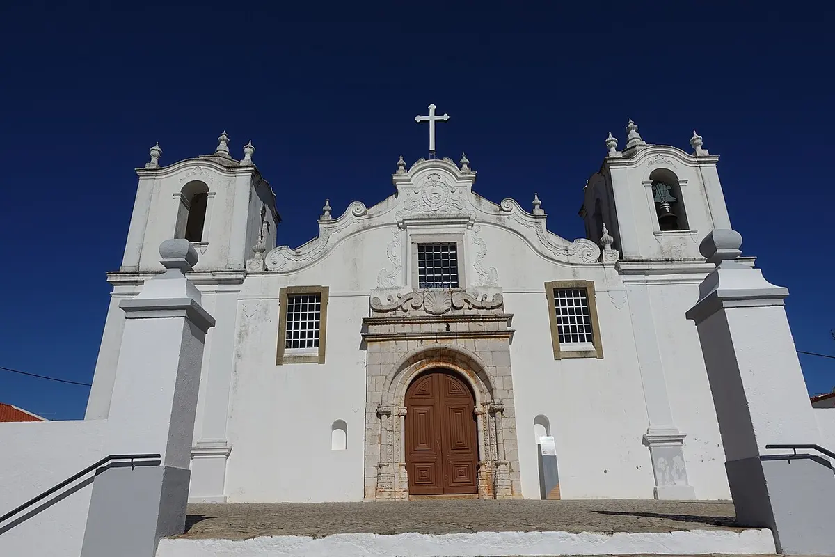 The white front and twin towers of São Tiago church in Estômbar
