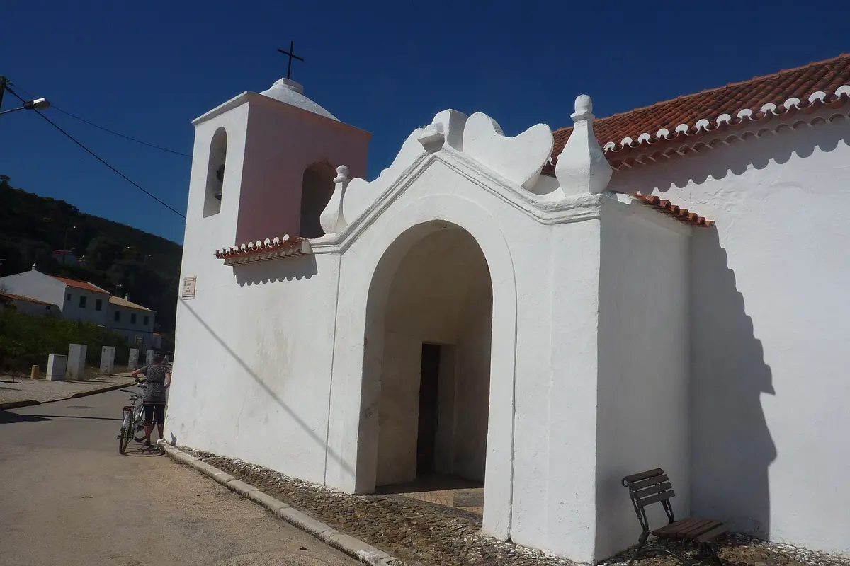 The low arched entrance and bell gable of the village church in Bordeira
