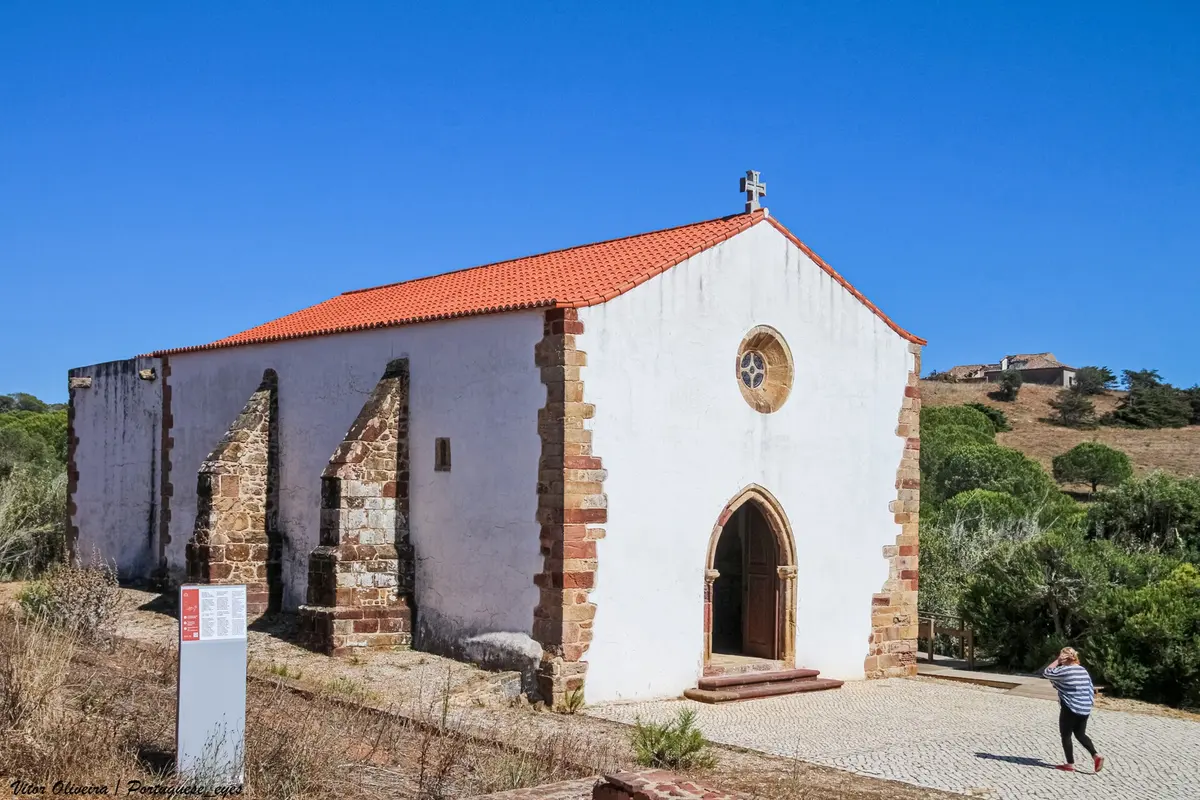 The stone-framed entrance and pale walls of Guadalupe chapel in its rural setting