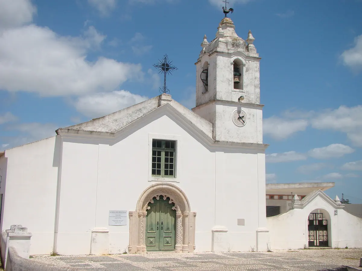 The white façade, carved doorway and bell tower of Odiáxere’s parish church