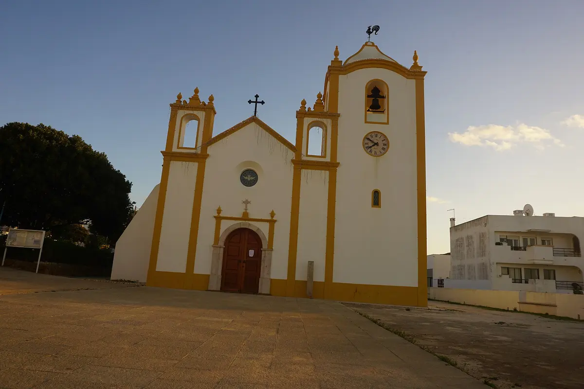 The illuminated façade of Nossa Senhora da Luz church at dusk