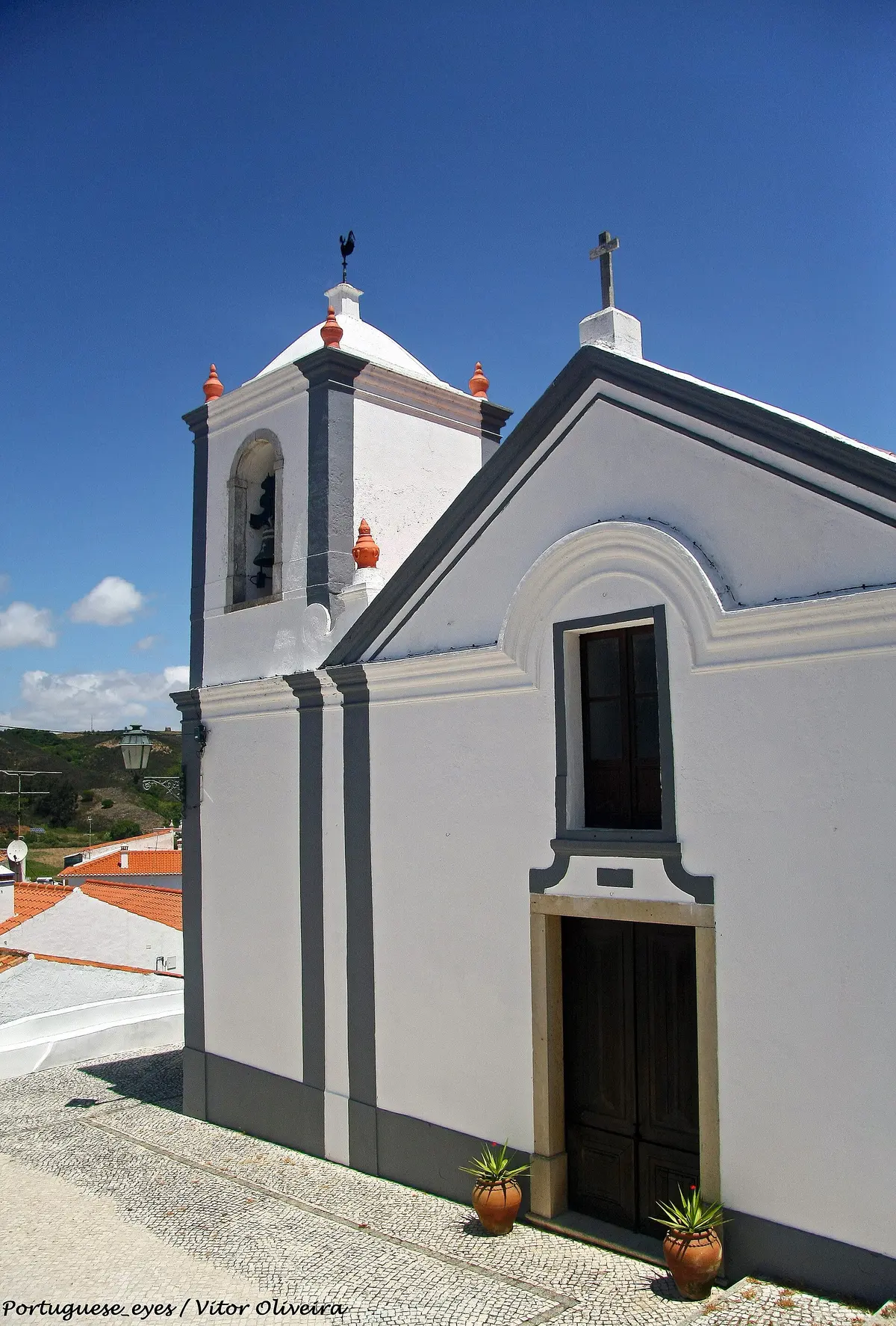 The white-and-blue façade and bell tower of the village church in Odeceixe