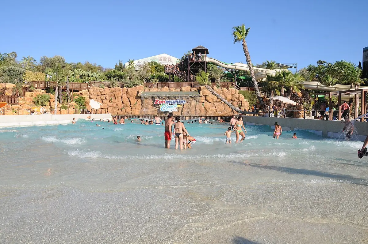 Wave pool with a rock backdrop and water slides at Zoomarine Algarve in Guia