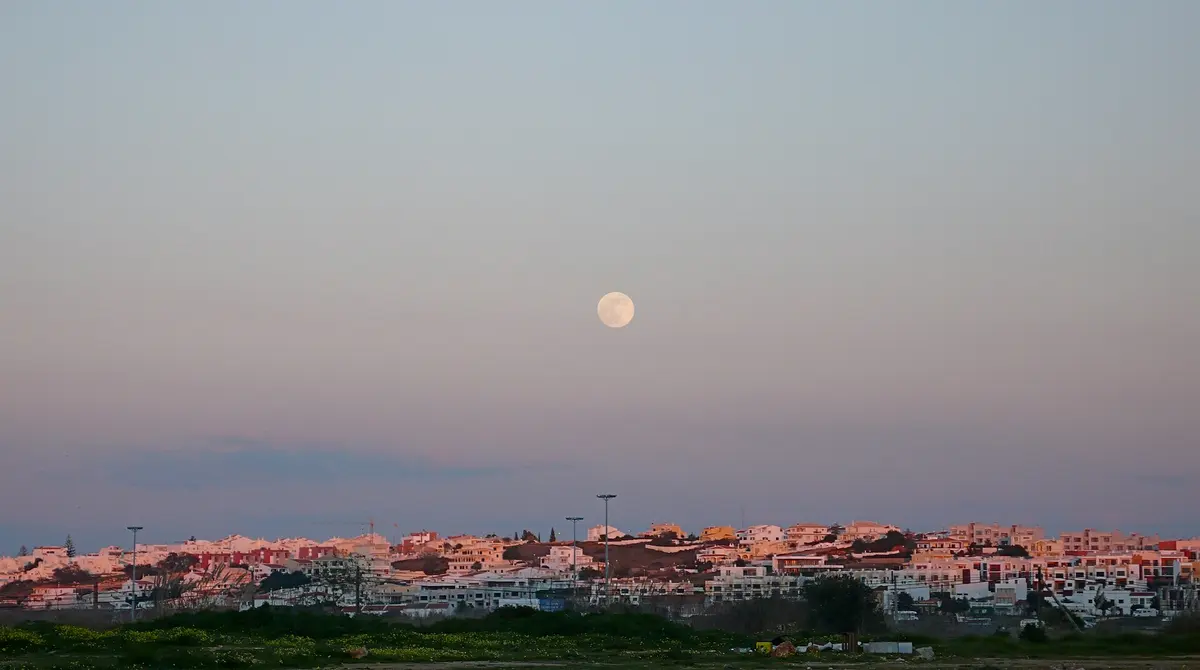 The moon above Ferragudo village viewed across the Arade