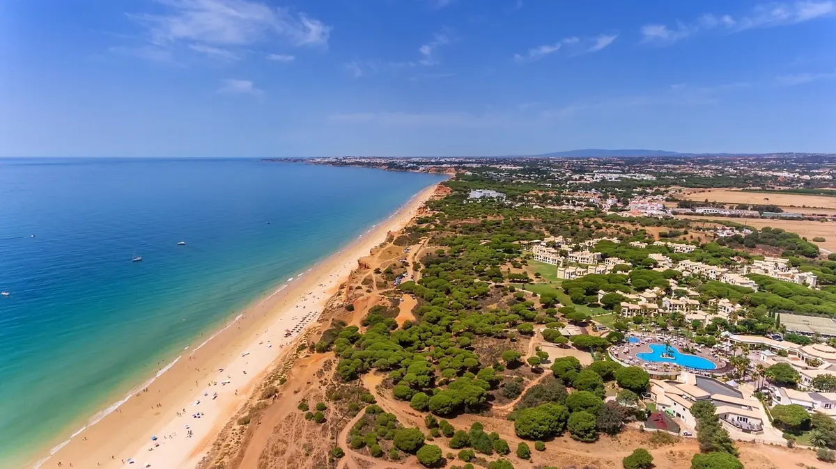 An aerial view across AP Adriana Beach Resort’s buildings and gardens beside the Falésia coastline