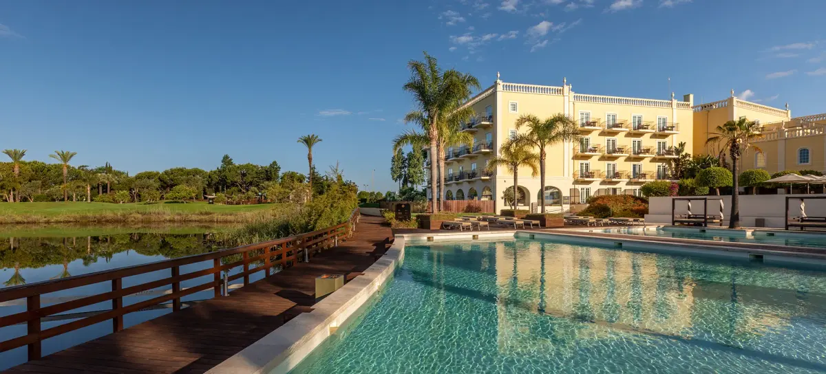 The pool, palms and hotel building at Domes Lake Algarve