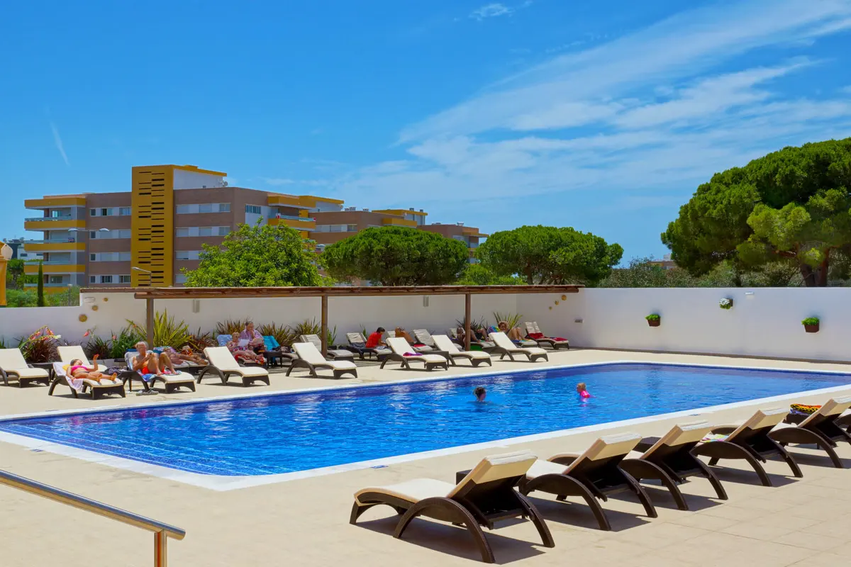 The outdoor pool and sun loungers in Hotel Zodíaco’s courtyard