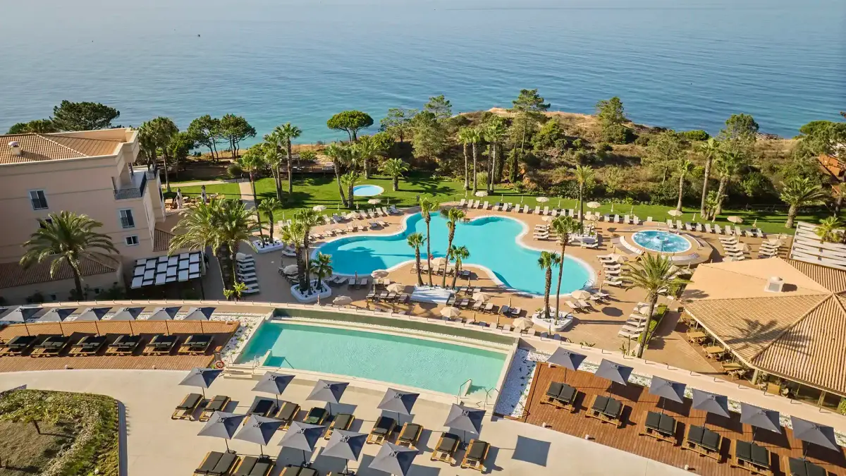 An aerial view of PortoBay Blue Ocean’s pools, gardens and coastal hotel buildings