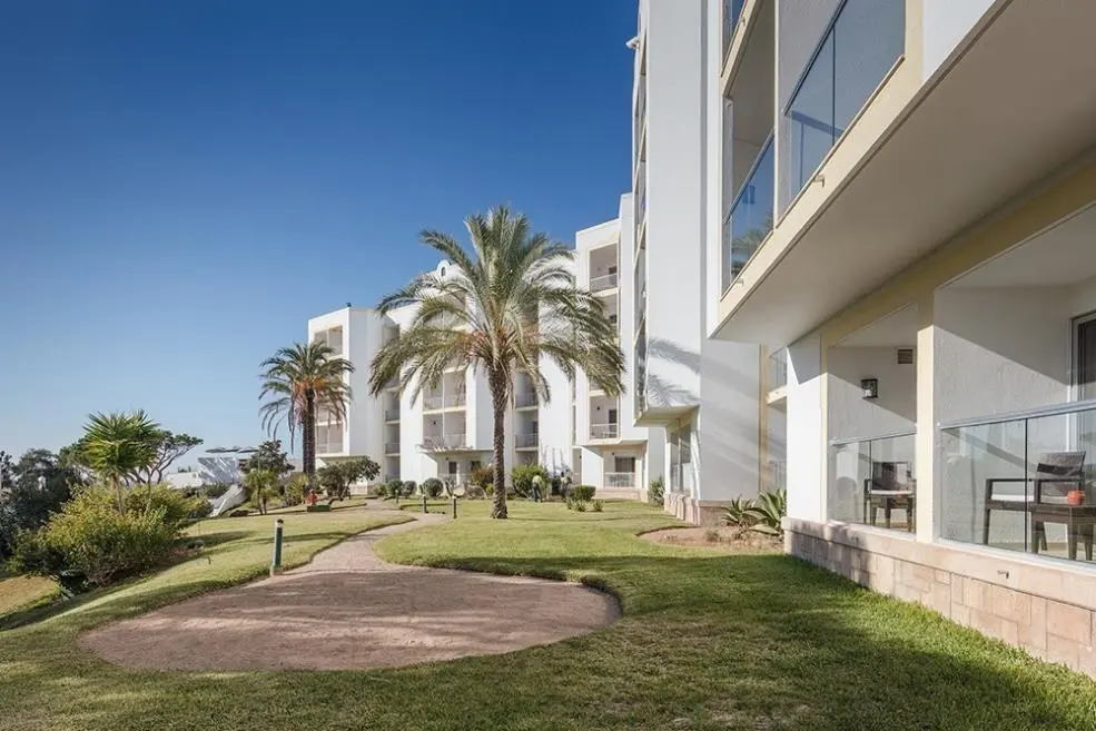 White hotel balconies, palm trees and landscaped gardens at Dona Filipa Hotel in Vale do Lobo
