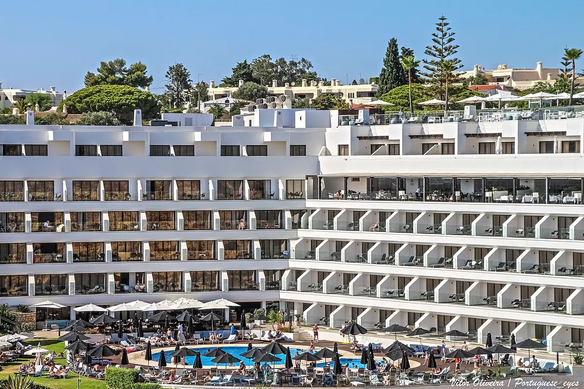 The white hotel balconies and pool terrace of Tivoli Carvoeiro above Vale Covo