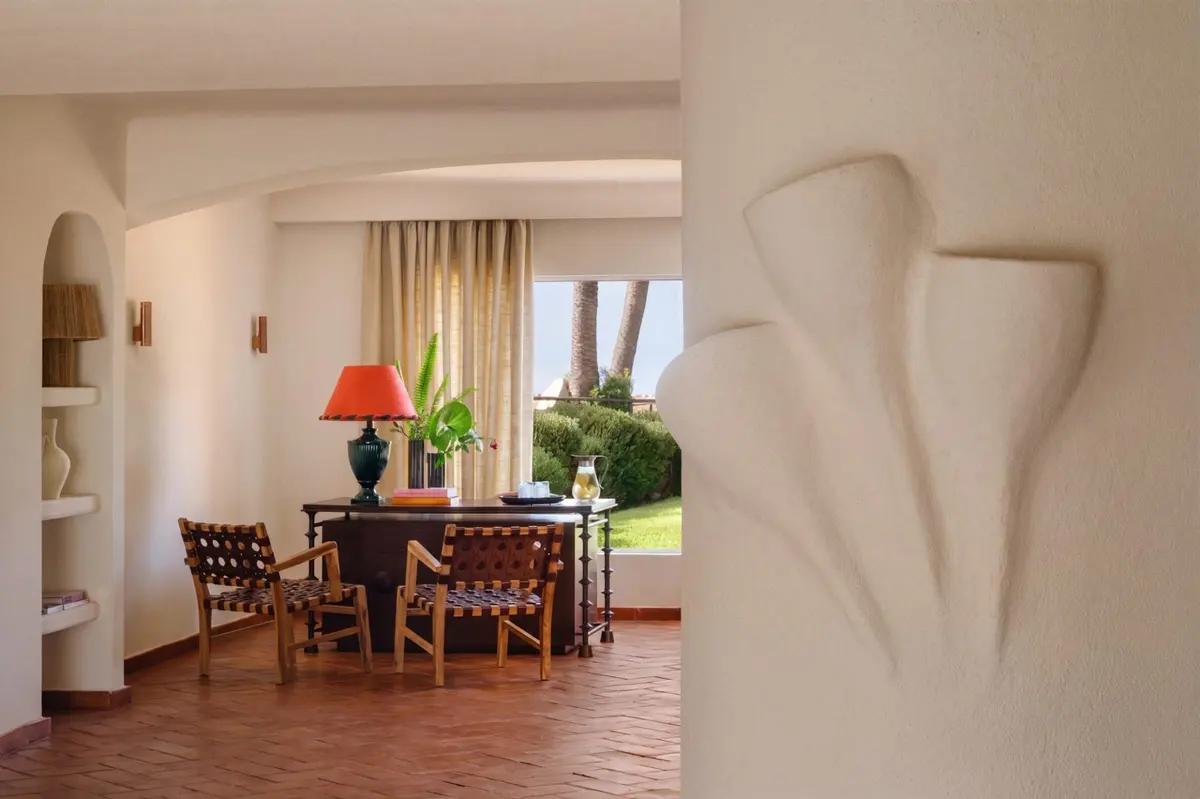 Soft white arches, a timber dining table and terracotta flooring inside Vilalara Grand Hotel Algarve