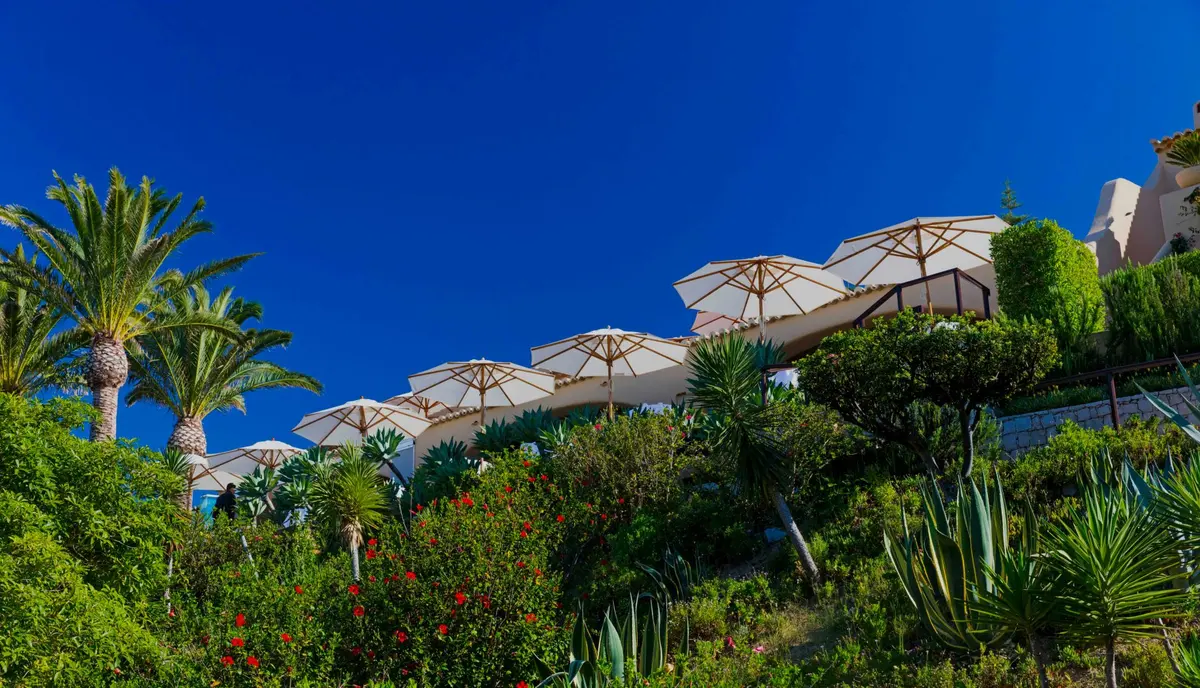 Vila Joya’s terraced gardens and parasols below the white hotel building