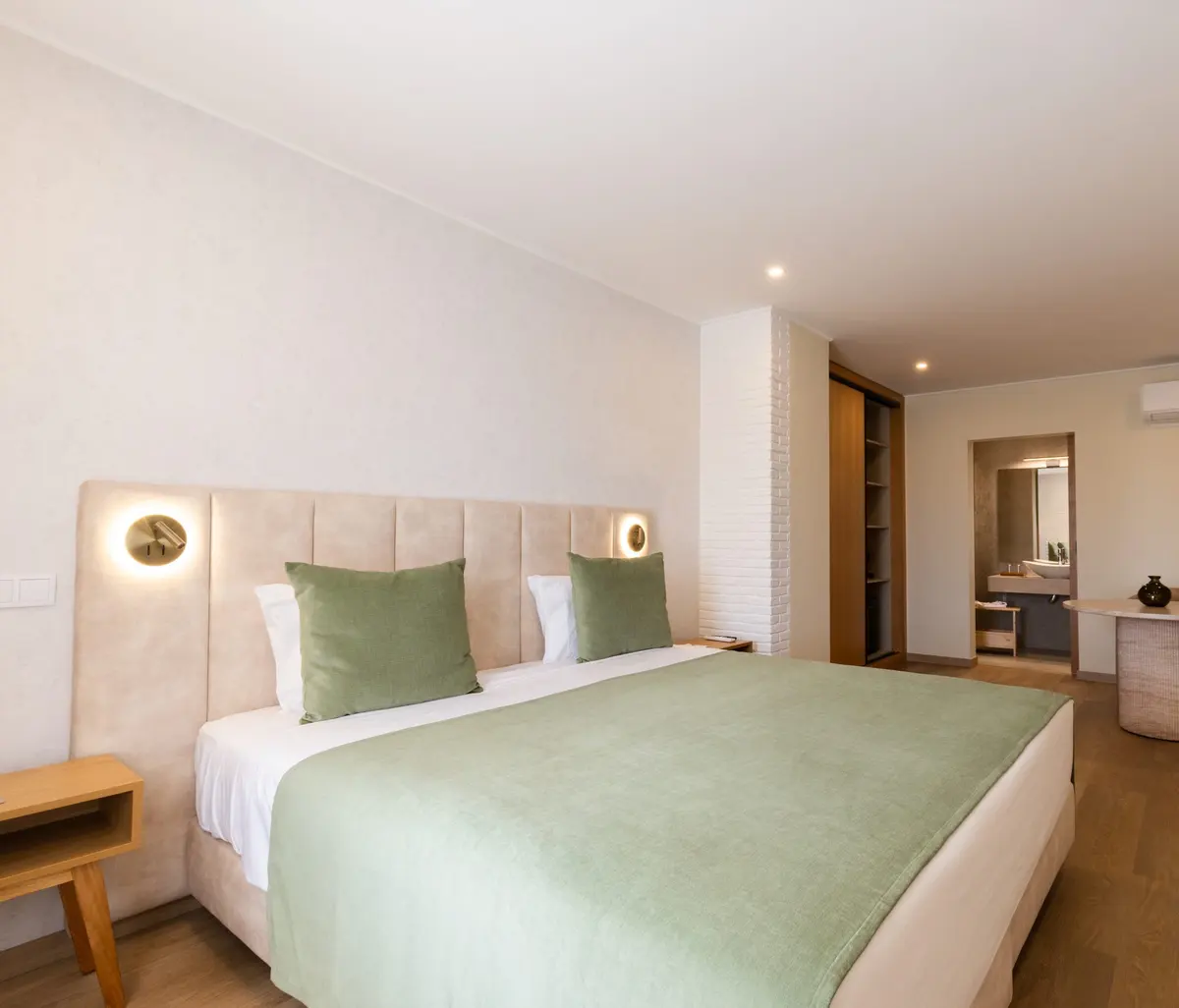 Light-filled guest room with a green bedspread at Hotel Rural Quinta do Marco