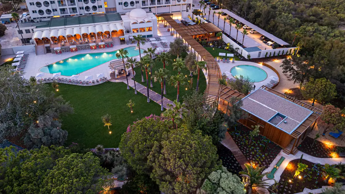 Elevated evening view of pools and gardens at OZADI Altura Beach Resort