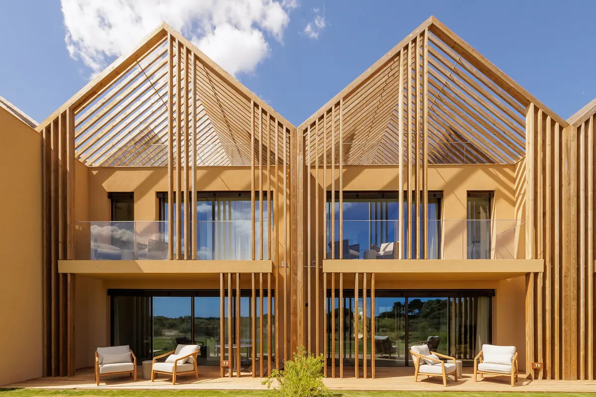 Two adjoining Verdelago Resort accommodation buildings with peaked timber screens and ground-floor terraces