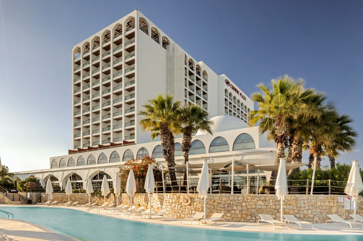The Crowne Plaza hotel tower and palm trees beside the swimming pool in Vilamoura