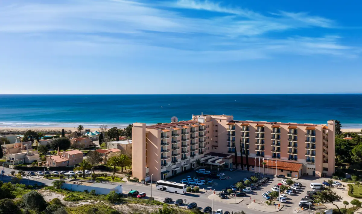 The peach-coloured Pestana Dom João II hotel building beside Alvor beach, viewed from above