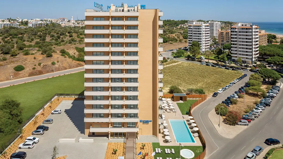 The tall Wyndham Alvor hotel building, its pool and terrace seen from above