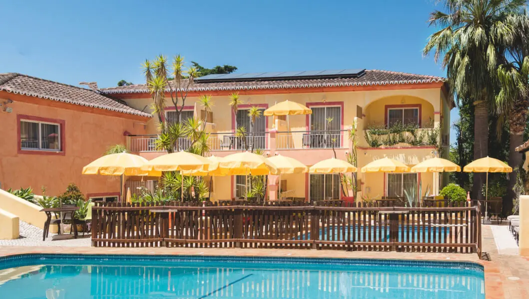 The warm-coloured hotel buildings and pool terrace at Costa d’Oiro Ambiance Village
