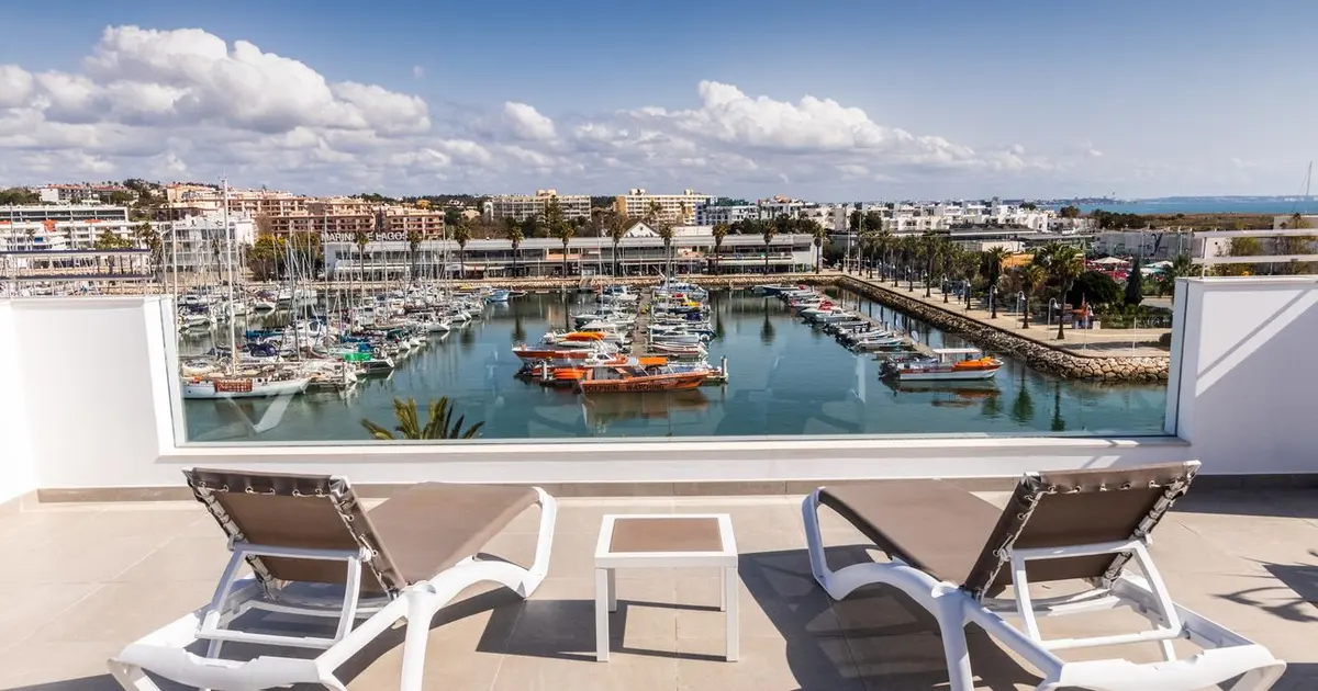 Sun loungers beside the small rooftop pool at Hotel Marina Rio, with the marina beyond