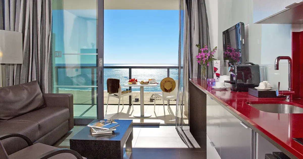 The sitting area and balcony view from a suite at RR Hotel da Rocha
