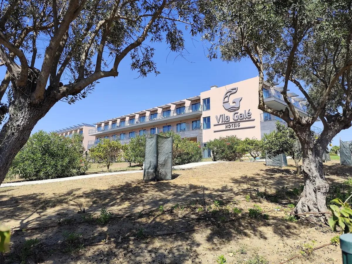 The Vila Galé Lagos hotel exterior seen between trees in Meia Praia