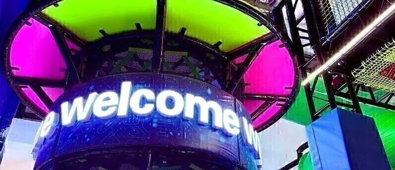 Brightly lit indoor play structure and welcome sign at Adventure HQ