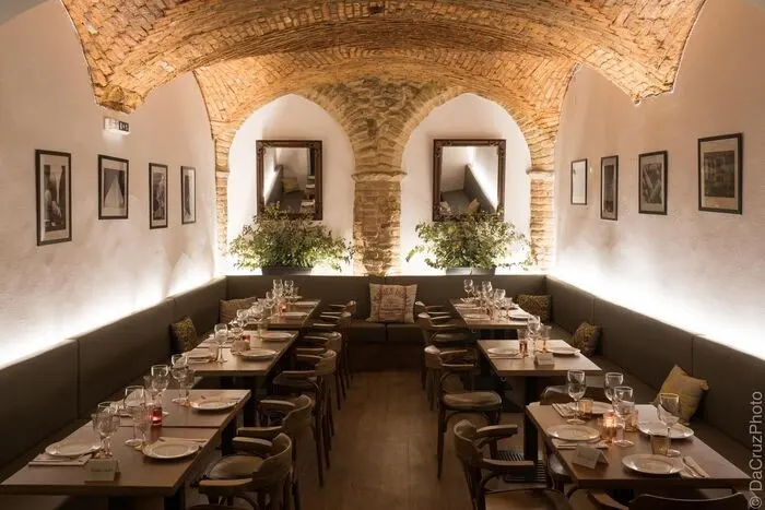 Set dining tables beneath a brick-vaulted ceiling at 11 da Villa in Loulé