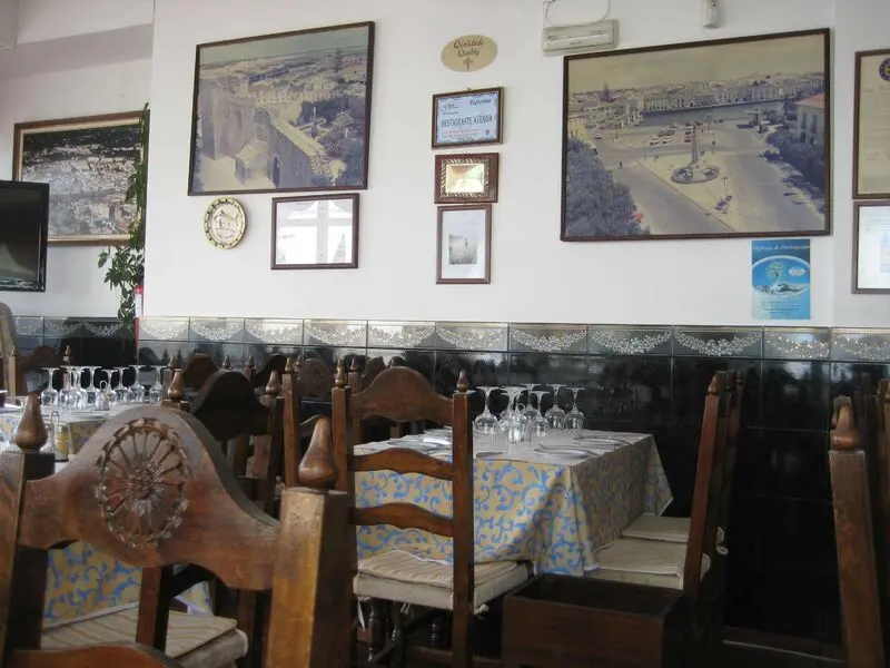 Wooden chairs and laid tables in Restaurante Avenida’s Tavira dining room.