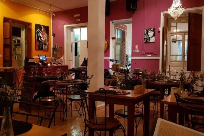 Dining tables, wall art and windows inside Café Inglês in historic Silves