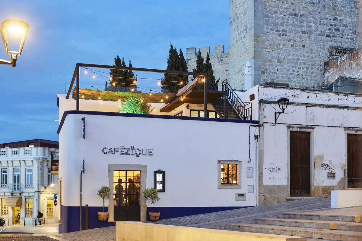 The CaféZïque building and rooftop dining area beside Loulé’s castle walls at dusk