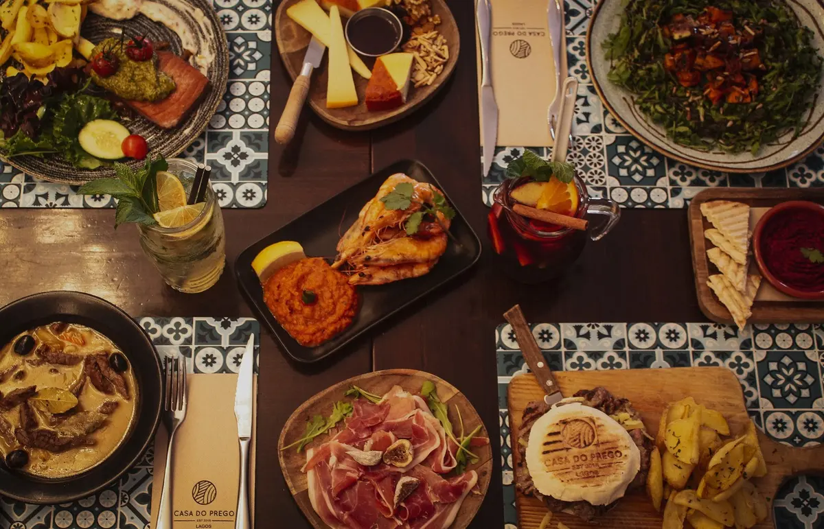 An overhead view of dishes and drinks on Casa do Prego’s patterned table