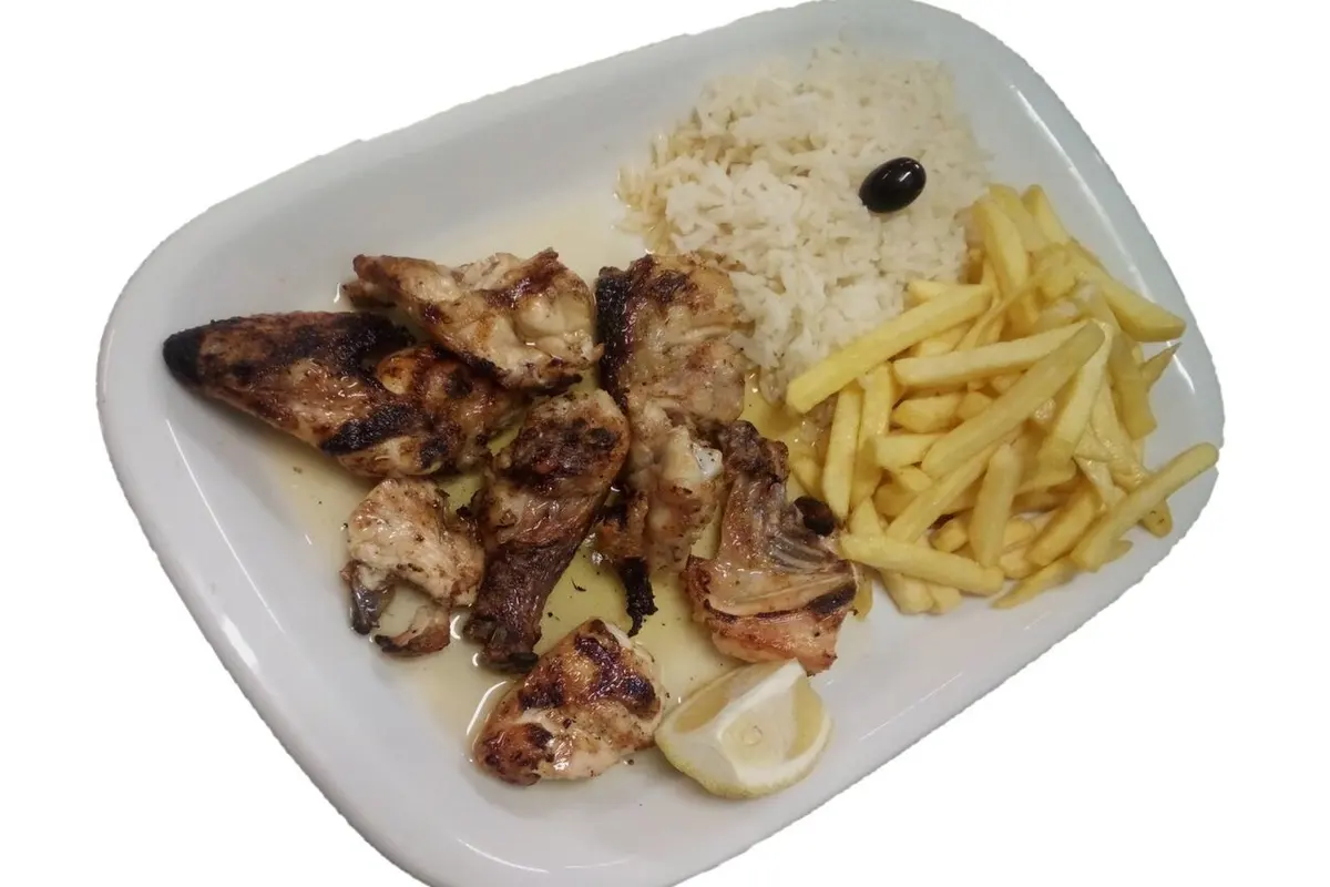 Grilled chicken served with rice, chips and lemon, presented as Chefe Branco’s Guia-style chicken speciality.