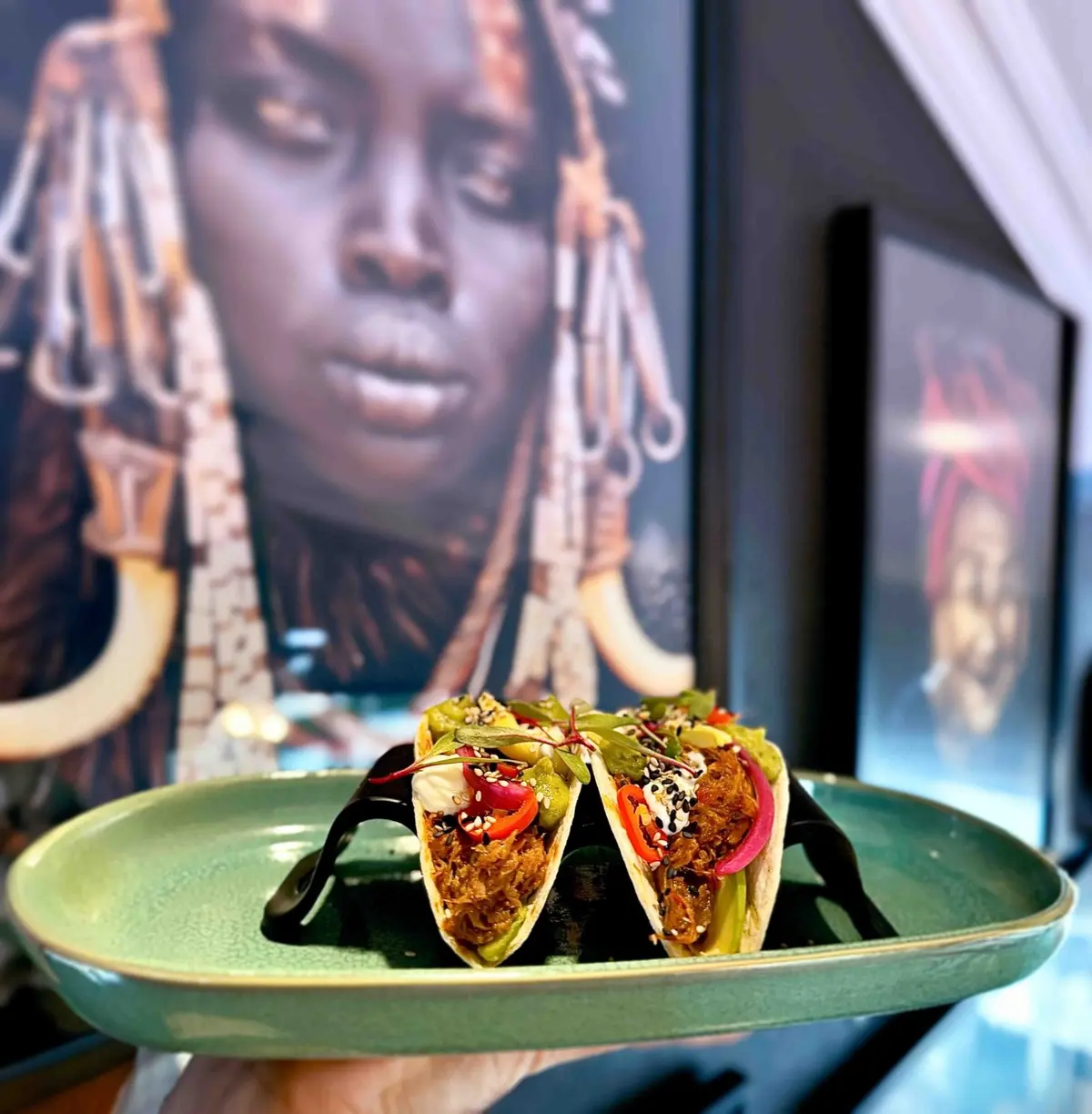 Sharing dish at Chef’s Kitchen in front of its wall art
