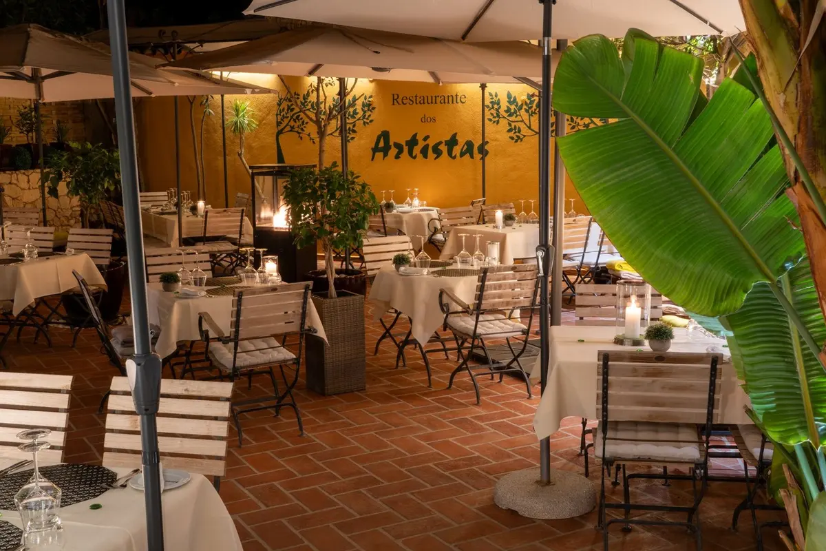 Set dining tables and tropical plants on Dos Artistas’ covered terrace