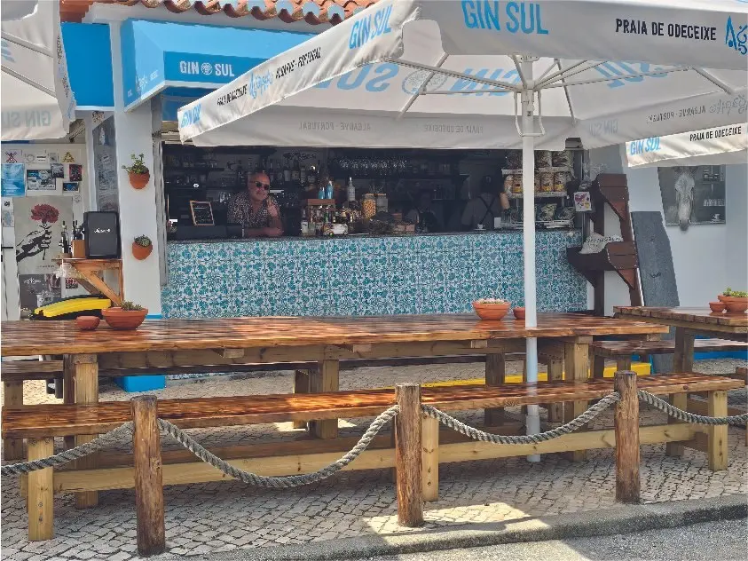 Beach-bar counter, umbrellas and wooden tables at Kiosk Agapito