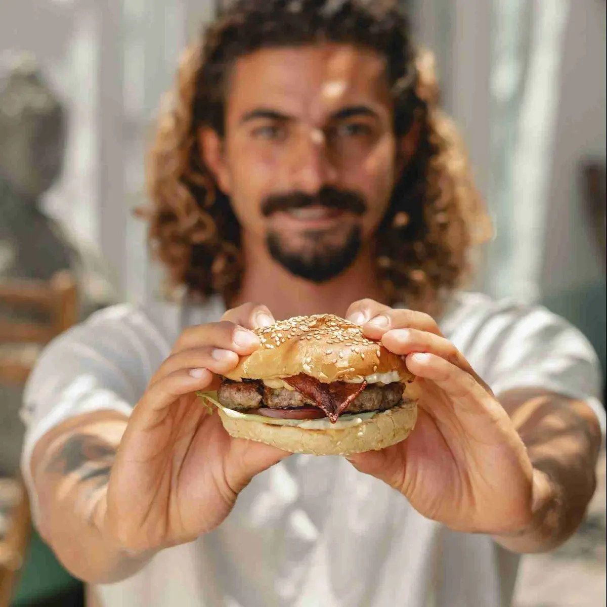 A man holding a burger at Laundry Lounge Sagres
