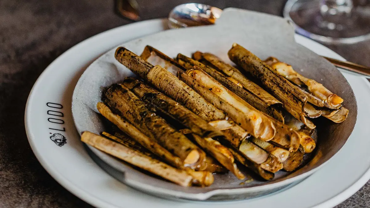 Razor clams served on a plate carrying Lodo’s name.