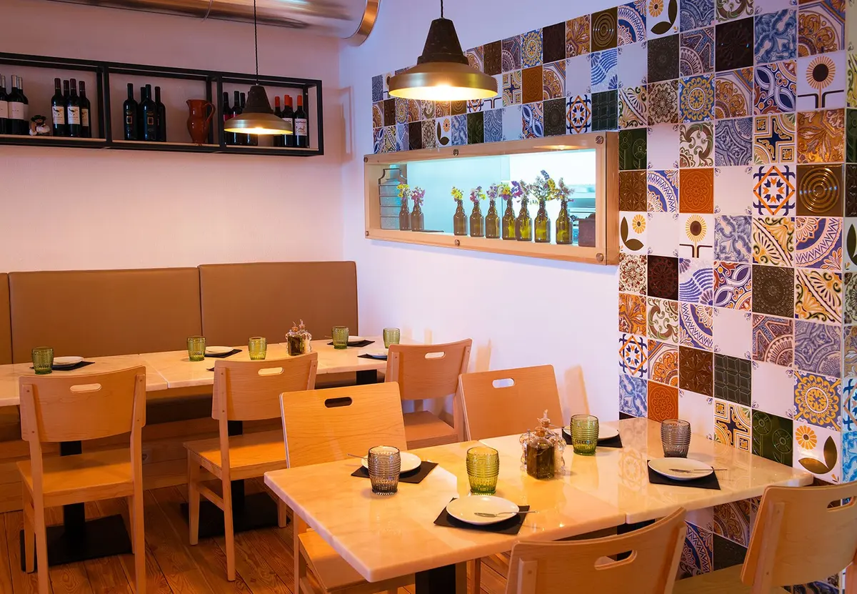Set tables beside the colourful tile wall in Mar d’Estórias restaurant