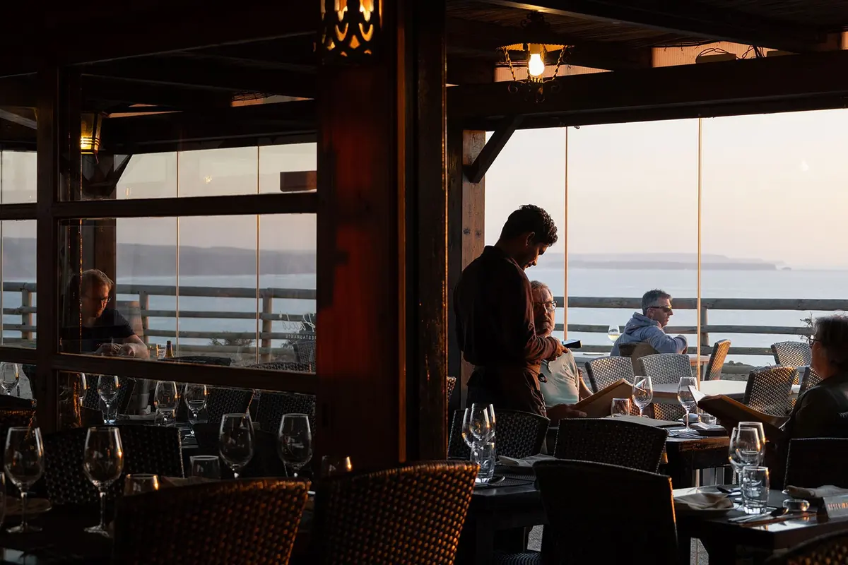 Wine glasses and set tables looking towards the sea at O Paulo
