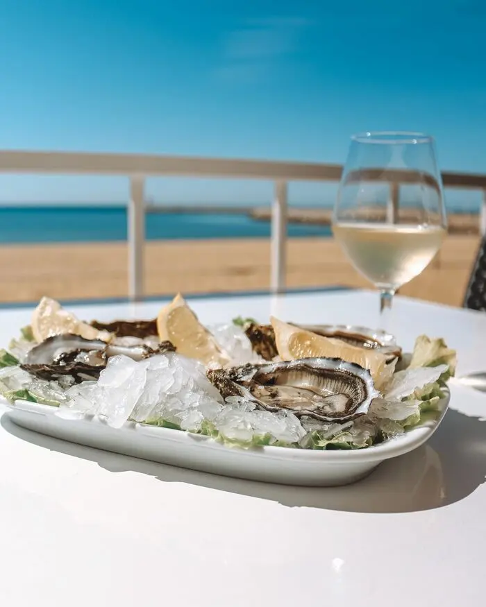 Oysters and a glass of wine on a table overlooking the sea at Rosa Branca